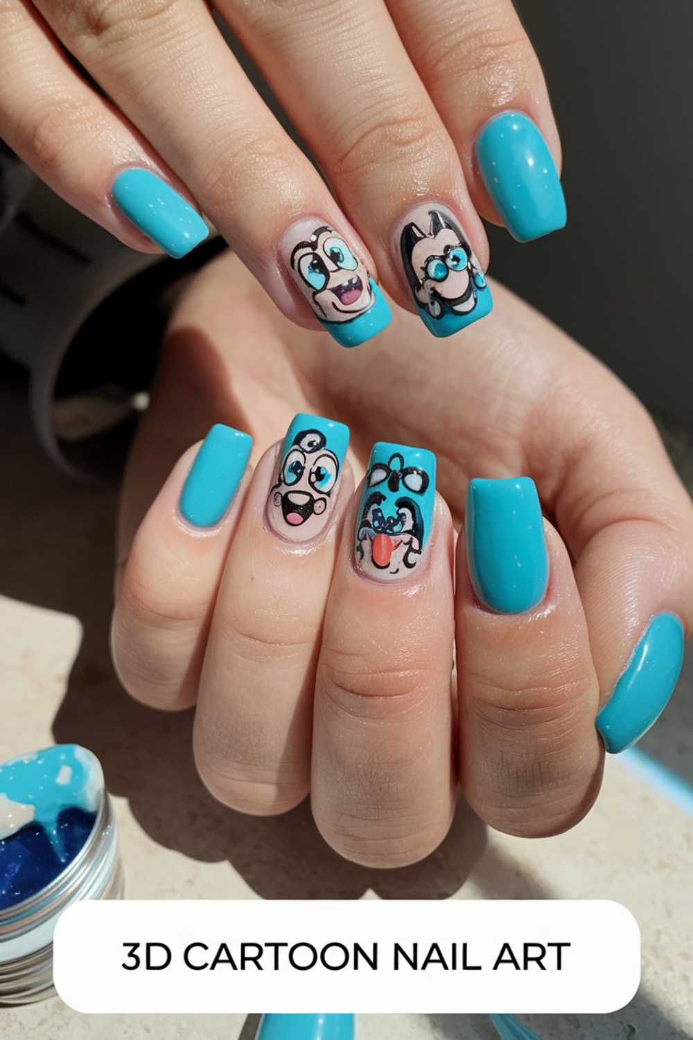 Close-up of a hand with turquoise nails featuring 3D cartoon nail art designs. Three nails display playful faces with big eyes and smiles, while the others are solid turquoise. A small container of nail gel is nearby. Text reads 3D CARTOON NAIL ART.