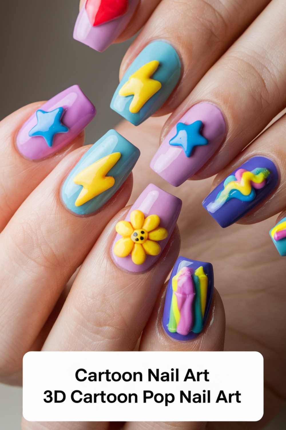 Close-up of hands showcasing vibrant 3D cartoon nail art designs, featuring a yellow lightning bolt, a purple star, and flowers on pink, purple, and blue backgrounds. Cartoon Nail Art Designs 3D Cartoon Pop Nail Art is elegantly inscribed at the bottom.
