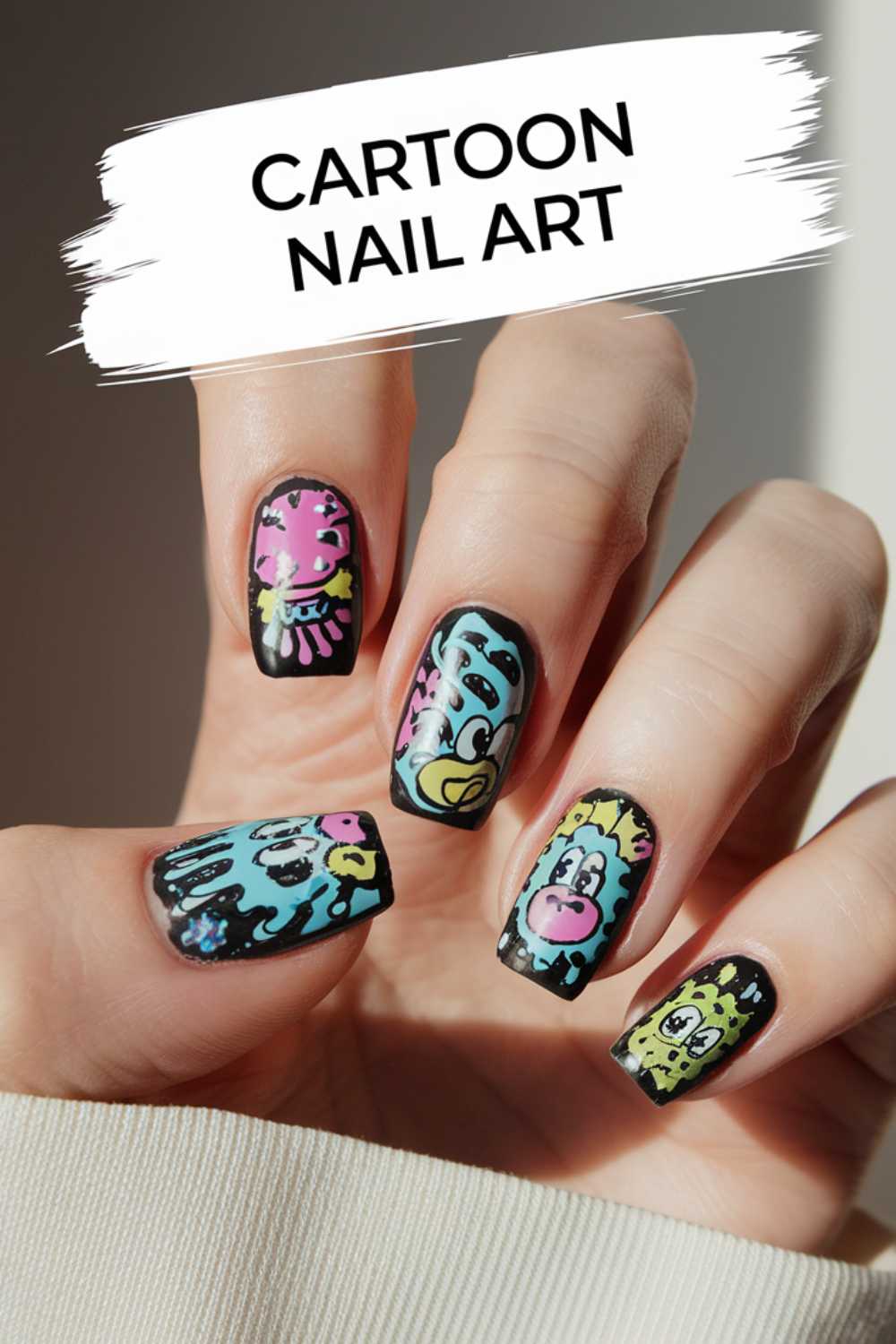 Close-up of a hand showcasing vibrant cartoon nail art designs. Each square-shaped nail features colorful, whimsical characters on a sleek black background. The text Cartoon Nail Art is elegantly displayed at the top.