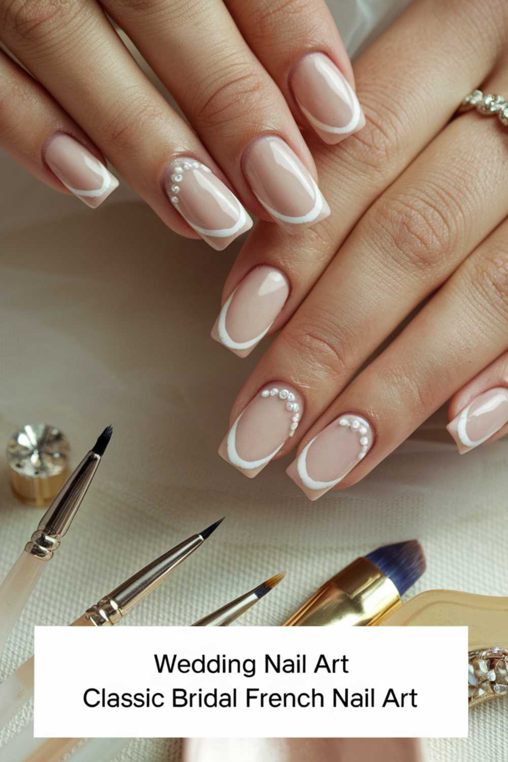 A close-up of elegantly manicured hands with French nail art featuring pearl embellishments. Brushes and nail polish bottles are visible nearby. The text reads, Wedding Nail Art Classic Bridal French Nail Art.