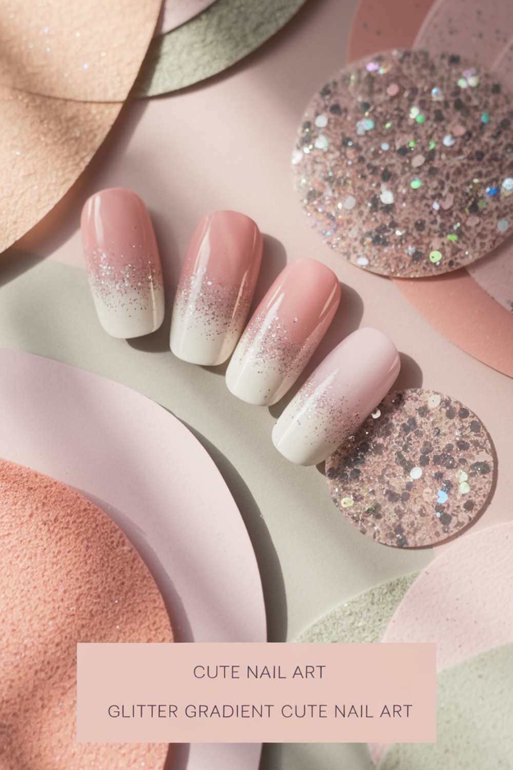 A set of press-on nails features a mesmerizing pink-to-white gradient with silver glitter tips. Displayed against a textured backdrop of pink and beige circles, the text proudly announces Glitter Gradient Cute Nail Art to highlight this chic style.