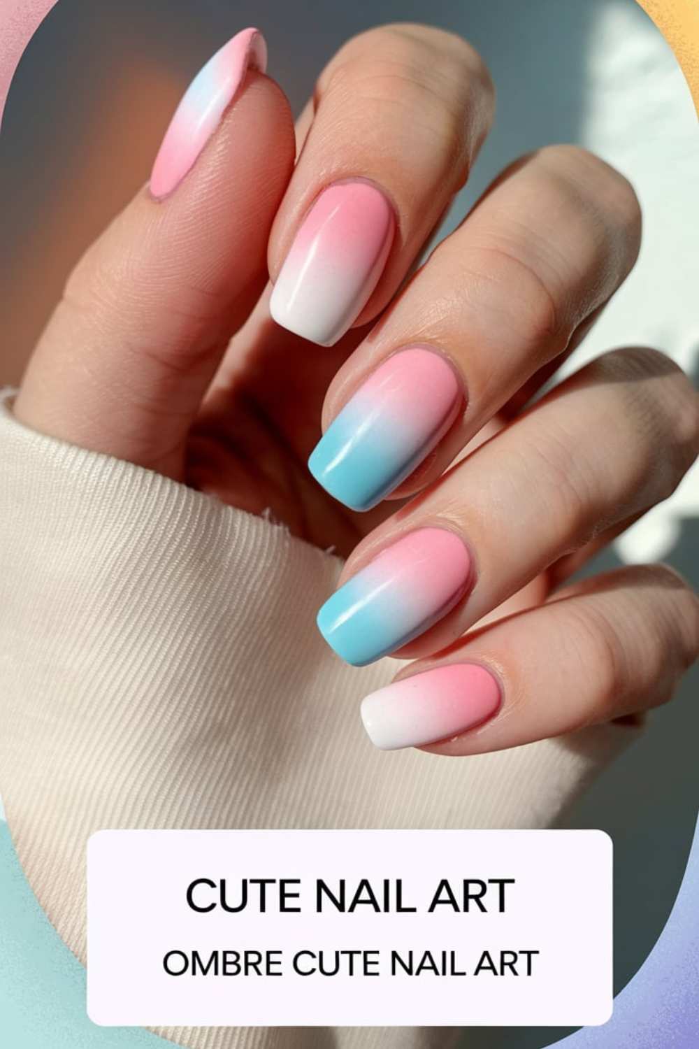A close-up captures a hand with pink, blue, and white ombre nails gently resting on beige fabric. This chic gradient design is the essence of Cute Nail Art, with Ombre Cute Nail Art elegantly displayed at the bottom.