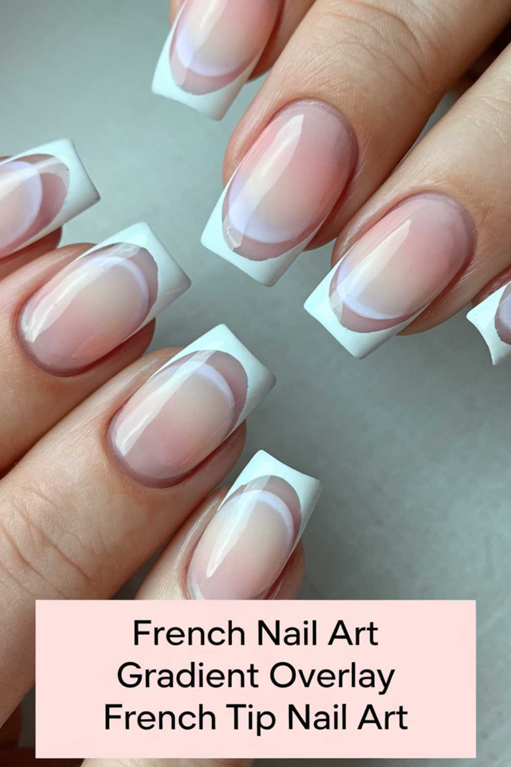 Close-up of hands with a French tip nail design featuring gradient overlays. Each nail has a classic white tip with a subtle pink-to-clear gradient and a delicate circular detail at the base. A text overlay reads: French Nail Art Gradient Overlay French Tip Nail Art.