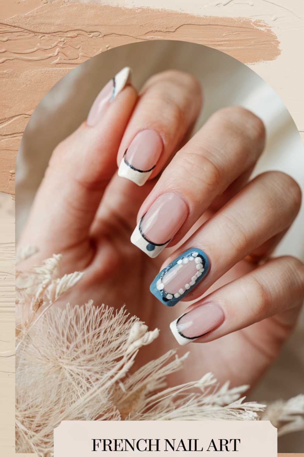 A hand displaying French nail art with a modern twist. The nails have white tips, black accents, and one nail features blue and pearl decorations. The background is soft and textured with beige tones and dried flowers. Text at the bottom reads French Nail Art.