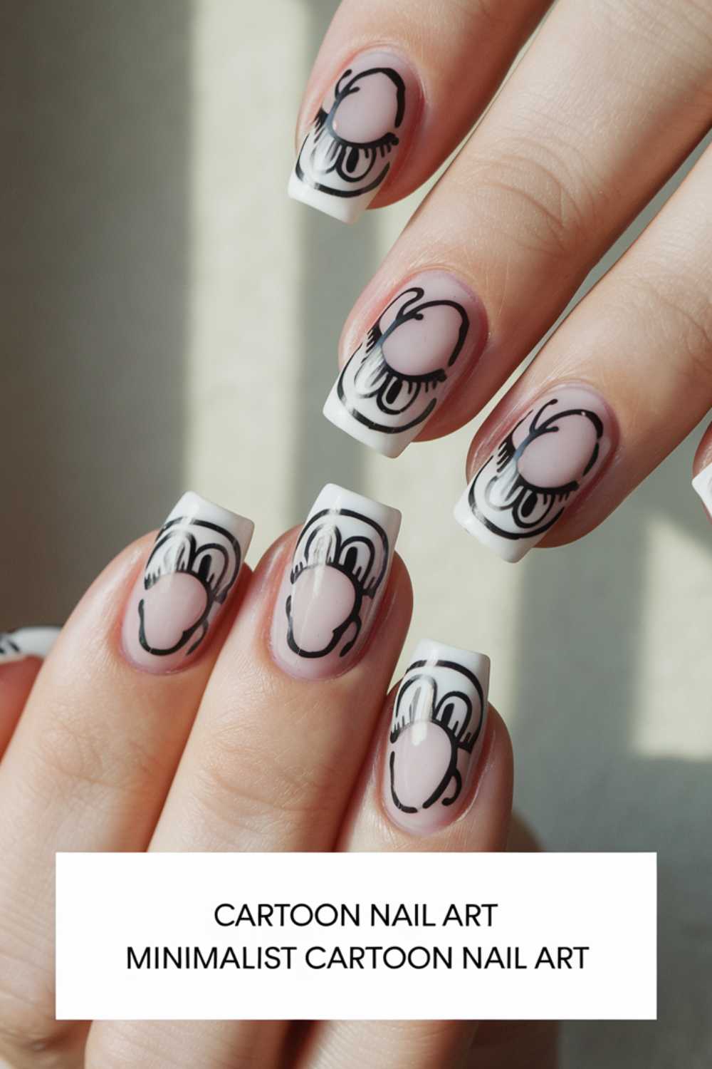 Close-up of hands featuring cartoon nail art designs with minimalist flair. Each nail showcases a stylized cartoon hand in various gestures, set against a nude background with white tips. Text at the bottom reads Cartoon Nail Art Minimalist Cartoon Nail Art.