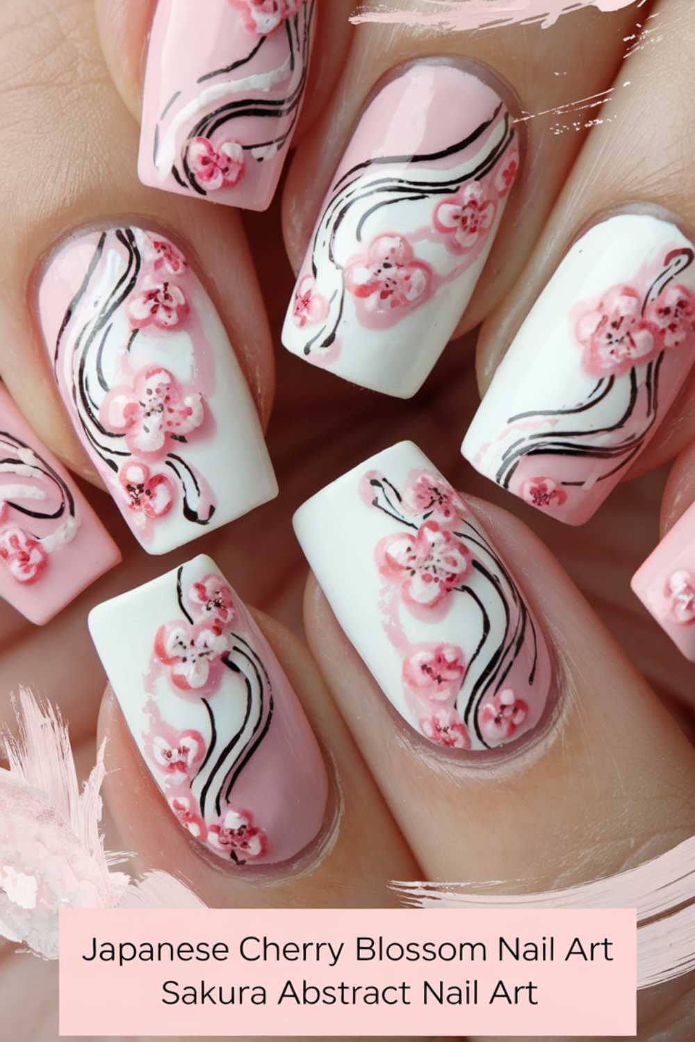 Close-up of nails featuring Japanese cherry blossom art. The design includes pink flowers on a soft white and pink background with black abstract lines. Text reads: Japanese Cherry Blossom Nail Art, Sakura Abstract Nail Art.