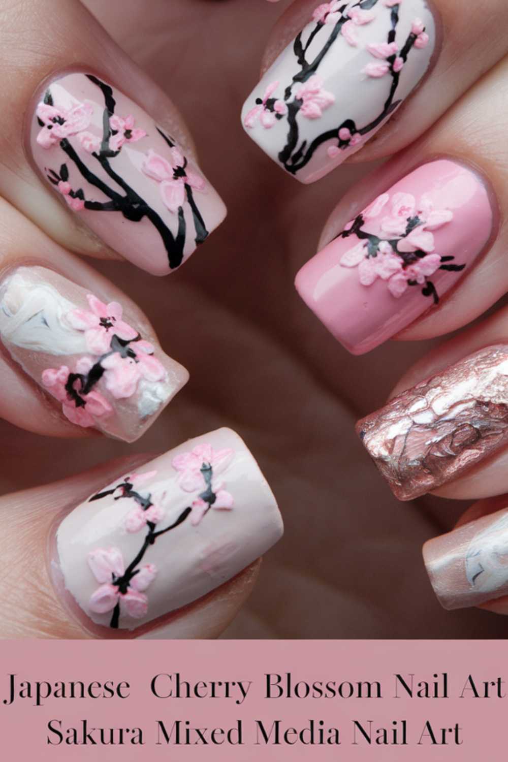 Close-up of a hand with five fingernails featuring cherry blossom art. Each nail displays delicate pink blossoms and branches on different backgrounds, including soft pink, white, and metallic textures. Text at the bottom reads: Japanese Cherry Blossom Nail Art.