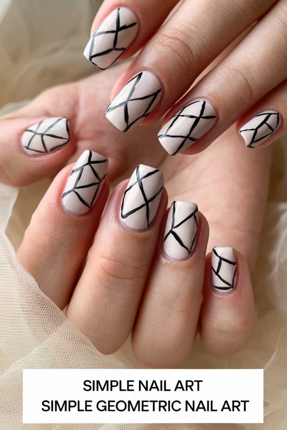 Close-up of hands showcasing simple nail art. The nails are painted with a creamy base color adorned with black crisscross lines forming a diamond pattern. Text at the bottom reads, Simple Nail Art, Simple Geometric Nail Art.