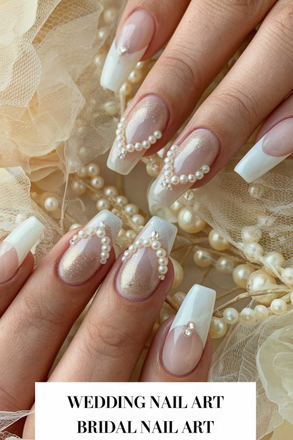 Close-up of elegant bridal nail art with a gradient of sheer pink to white. Pearls adorn each nail, creating a sophisticated, wedding-themed look. The background features delicate fabric and scattered pearls, enhancing the bridal aesthetic.