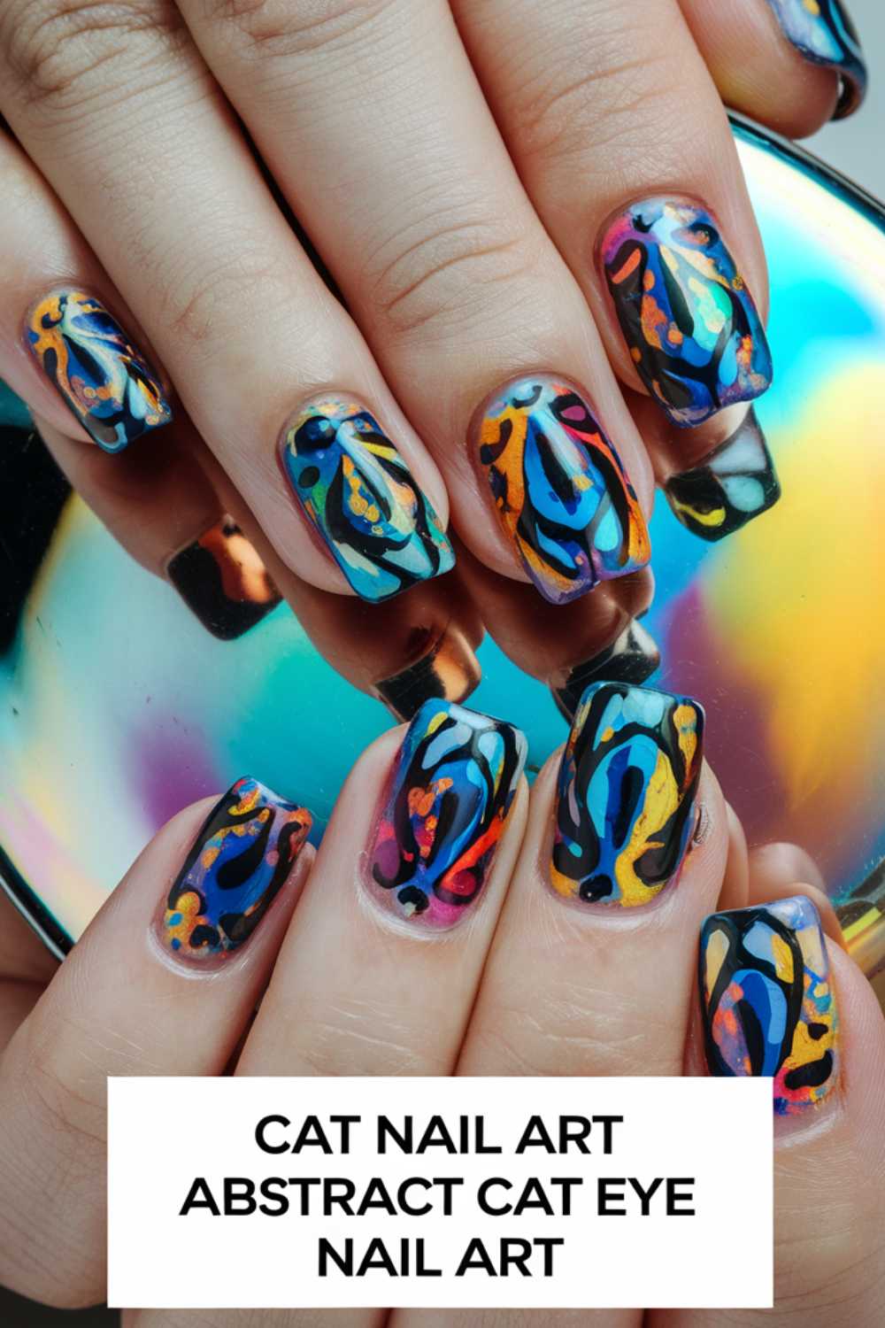 Close-up of hands with vibrant cat-inspired abstract nail art. Each nail features colorful swirled patterns resembling cats eyes, with hues of blue, orange, yellow, and pink. A text overlay reads: Cat Nail Art Abstract Cat Eye Nail Art.