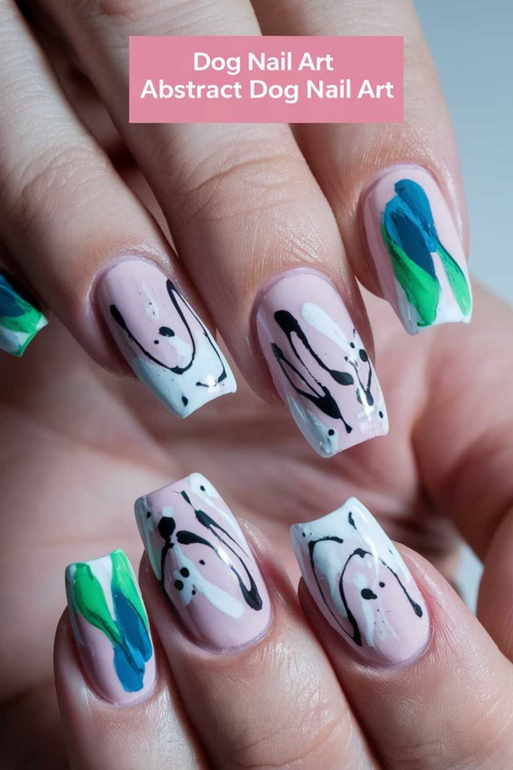 Close-up of nails showcasing Dog Nail Art with abstract designs. Black and white swirls artfully resemble dogs on a few nails, while others feature green and blue shapes. A pink label above reads: Abstract Dog Nail Art.