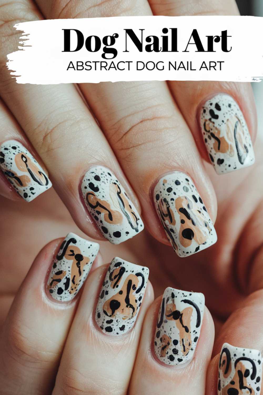 A close-up of hands flaunting stunning Dog Nail Art. The nails display a white canvas adorned with black, brown, and cream abstract markings, mimicking dog-like spots and outlines. Bold text above declares: Abstract Dog-Themed Nail Art.