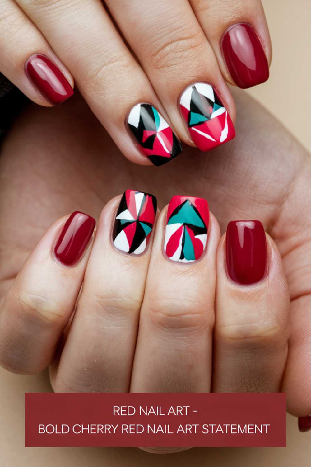 Close-up of hands showing vibrant red nails with geometric designs on two accent nails in black, white, red, and teal. Text at the bottom reads: RED NAIL ART - BOLD CHERRY RED NAIL ART STATEMENT.