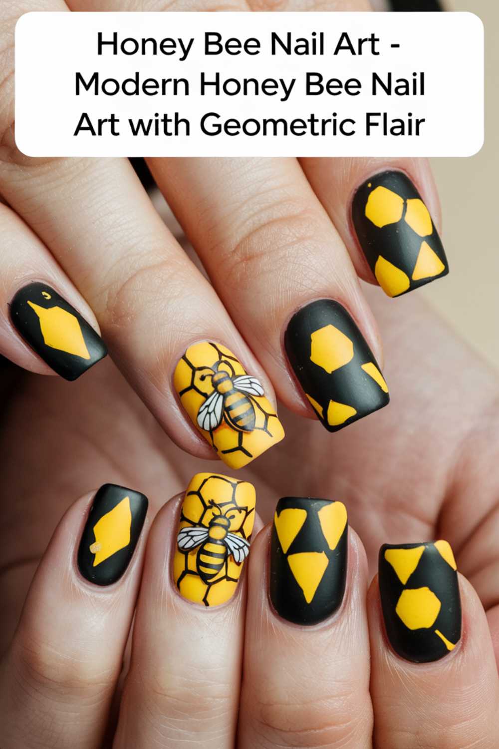 Close-up of hands showcasing bee nail art with a black and yellow honey bee theme. Designs include hexagons and bee illustrations on a matte black background, with each nail featuring a unique geometric pattern.