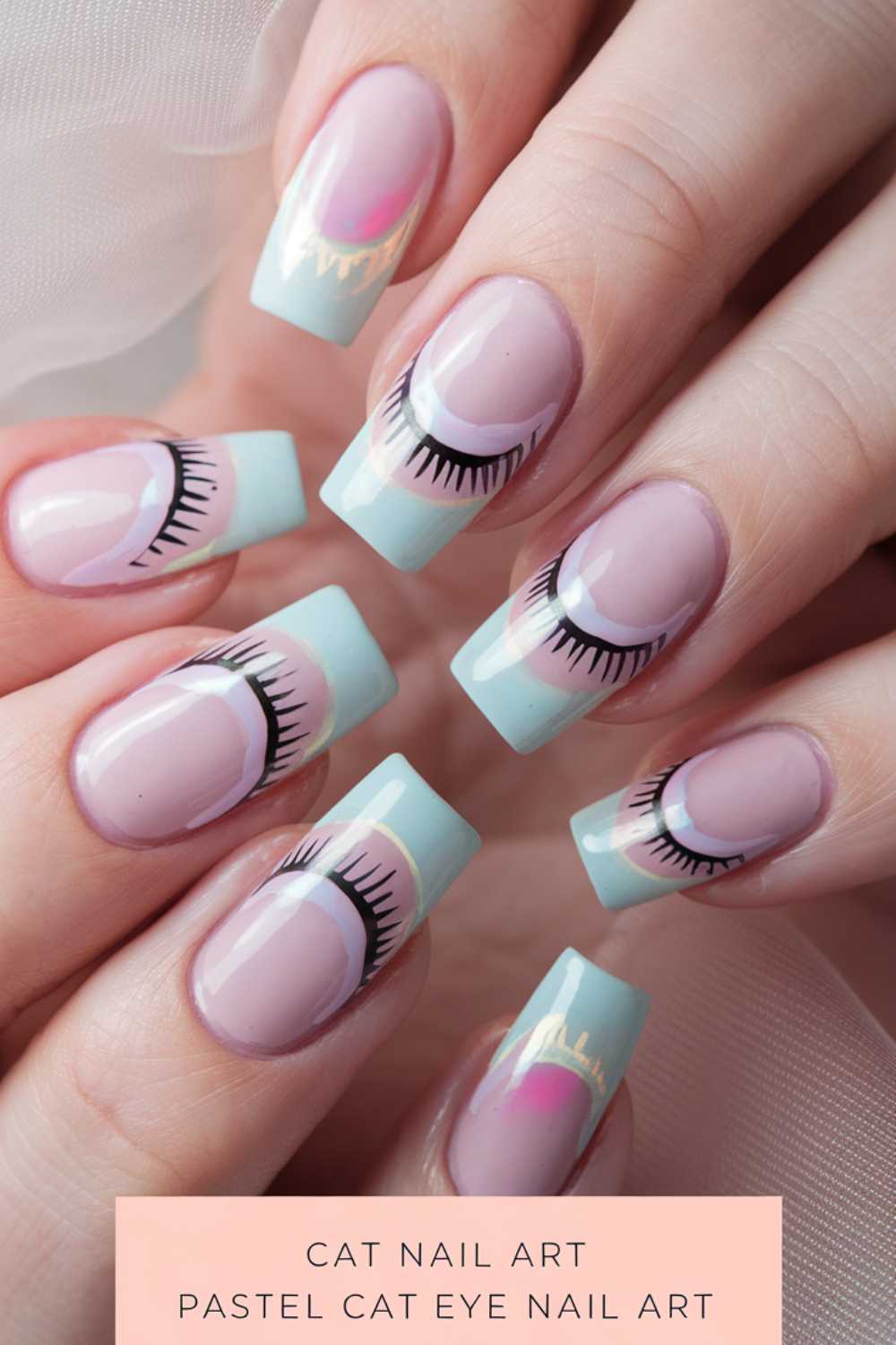 Close-up of hands with pastel cat eye nail art. Nails are painted light pink with light blue tips, featuring closed eye designs. A caption at the bottom reads Cat Nail Art Pastel Cat Eye Nail Art.