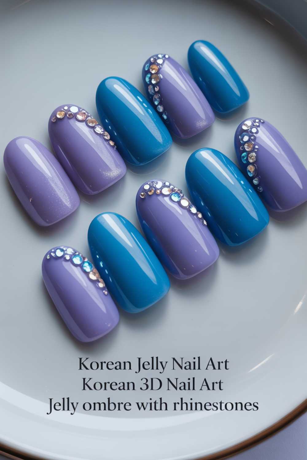 A set of jelly ombre press-on nails in blue and purple shades, each decorated with rhinestones along the cuticle area, displayed on a white plate. Text below describes the nail art styles.