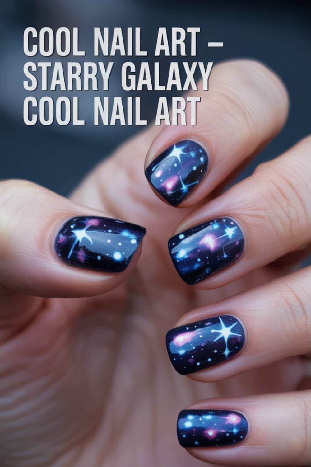 A hand displays fingernails painted with starry galaxy nail art in dark blue, featuring stars and cosmic patterns. Text reads: Cool Nail Art – Starry Galaxy Cool Nail Art.